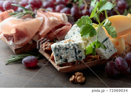 Various cheeses , grapes and prosciutto . Various cheeses , grapes and prosciutto . 72069034