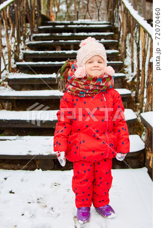Winter outdoor portrait of adorable dreamy baby girl in knitted hat and scarf Winter outdoor portrait of adorable dreamy baby girl in knitted hat and scarf 72070460
