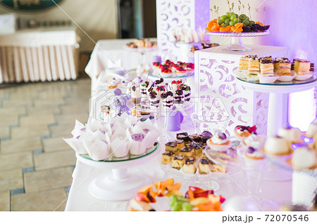 Delicious sweets on wedding candy buffet with desserts, cupcakes 72070546