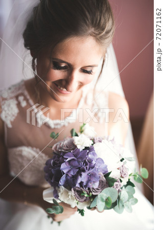 Gorgeous bride in robe posing and preparing for the wedding ceremony face in a room 72071162