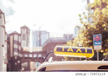 taxi car with a yellow sign on the roof in the city streets 72072113