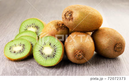 Kiwi whole and halves close-up on wooden background Kiwi whole and halves close-up on wooden background 72072373