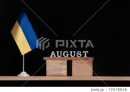 Wooden calendar of August with Ukrainian flag on black background. Dates in Ukraine in August Wooden calendar of August with Ukrainian flag on black background. Dates in Ukraine in August 72078818