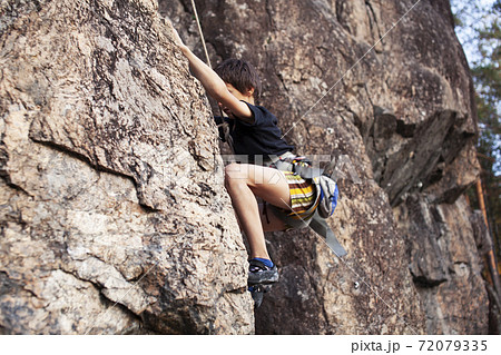 cute teen kid climbing on rock with insurance, lifestyle sport people concept cute teen kid climbing on rock with insurance, lifestyle sport people concept 72079335
