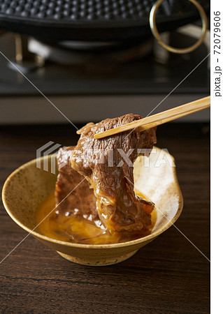 すき焼きの肉を玉子につける すき焼きの肉を玉子につける 72079606
