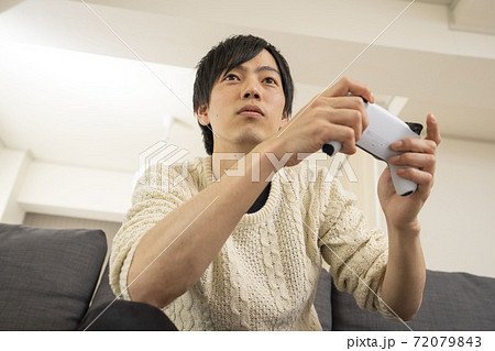 最新テレビゲーム機に夢中になる男性/プレステ/リビング 72079843