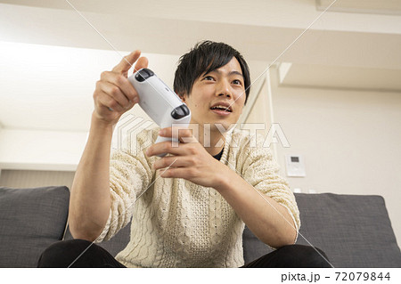 最新テレビゲーム機に夢中になる男性/プレステ/リビング 72079844