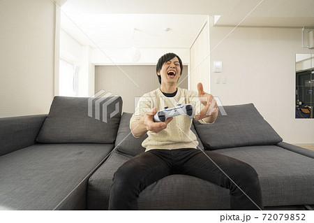 最新テレビゲーム機に夢中になる男性/プレステ/リビング 72079852