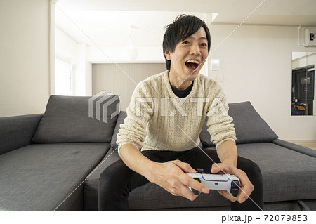 最新テレビゲーム機に夢中になる男性/プレステ/リビング 72079853