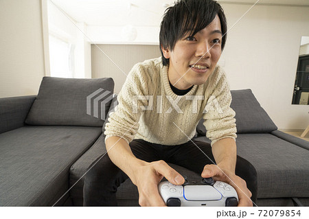 最新テレビゲーム機に夢中になる男性/プレステ/リビング 72079854