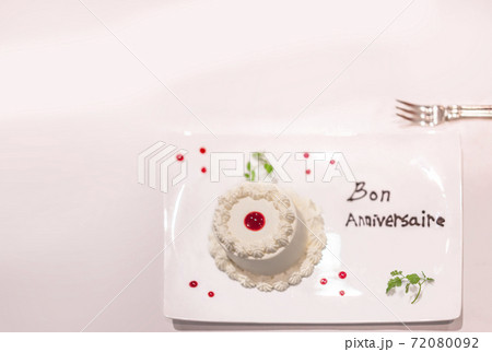 フレンチ料理のデザートのフランス語で書いてあるお誕生日おめでとうのホワイトケーキ。 フレンチ料理のデザートのフランス語で書いてあるお誕生日おめでとうのホワイトケーキ。 72080092