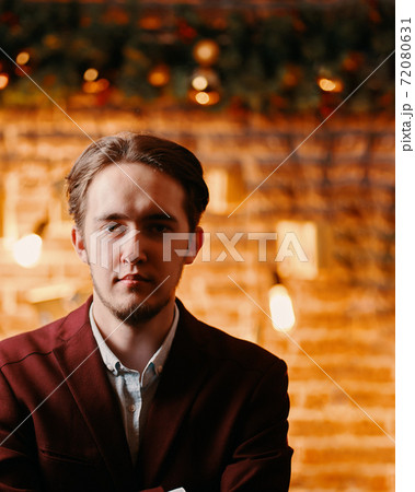 Young man in jacket on background of Christmas decorations. Young man in jacket on background of Christmas decorations. 72080631