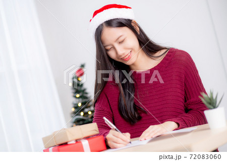 Young asian woman writing postcard in Christmas day at home, eve and celebrate. Young asian woman writing postcard in Christmas day at home, eve and celebrate. 72083060