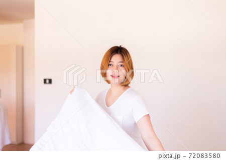 Make a bed,Asian women making her bed in room after wake up Make a bed,Asian women making her bed in room after wake up 72083580