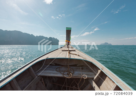 Traveling in Thailand. Amazing view from over Thai traditional wooden longtail boat travel on the sea tropical island with scenery of beautiful sea and sky. 72084039