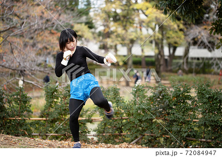 公園で格闘技のトレーニングをする女性 72084947