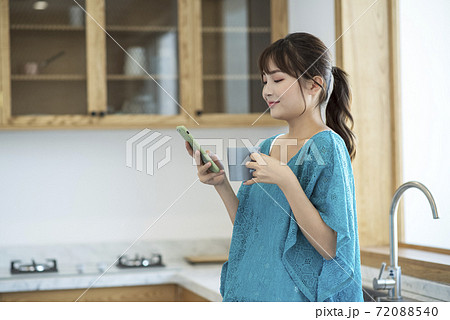 A young woman drinking coffee and using smartphone A young woman drinking coffee and using smartphone 72088540