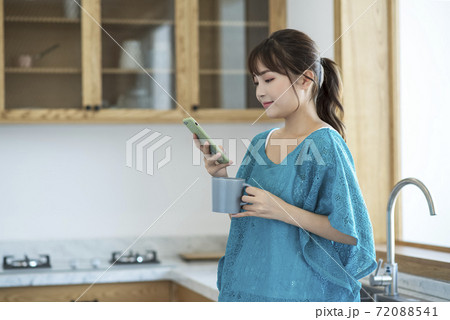 A young woman drinking coffee and using smartphone A young woman drinking coffee and using smartphone 72088541