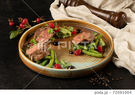 Pork medallion with asparagus and pea puree. Hot meat dish with vegetable garnish. Pork medallion with asparagus and pea puree. Hot meat dish with vegetable garnish. 72091004
