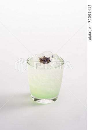 Summer refreshing cocktail with ice and alcohol. Sparkling water, gin, lemongrass syrup, Yuzu puree, lemon juice, estragon syrup. 72091412