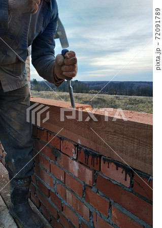 Man in gloves, work with a hammer and a bit of wood processing 72091789