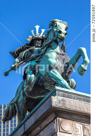 東京皇居外苑の楠木正成公騎馬銅像。斜め正面の角度。斜順光。背景は青空と丸の内地区のビルの一部。 東京皇居外苑の楠木正成公騎馬銅像。斜め正面の角度。斜順光。背景は青空と丸の内地区のビルの一部。 72091897