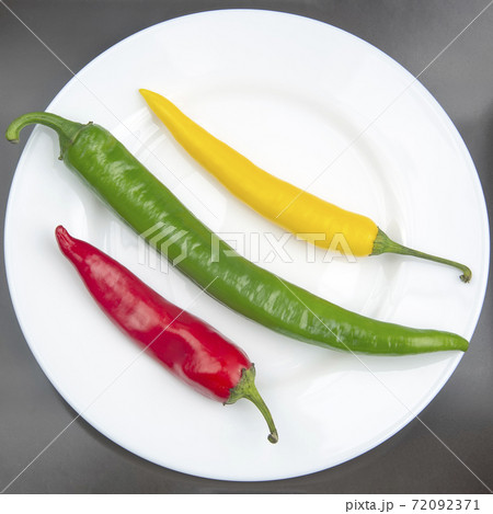 yellow, red and green hot chili on a plate. Pepper. Vegetable vitamin food. 72092371