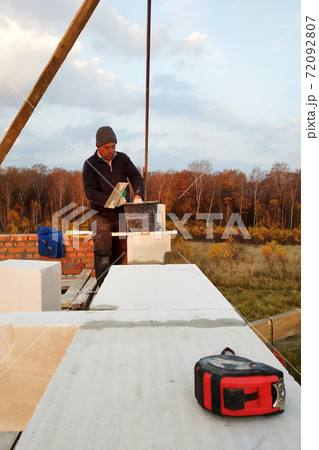 The masonry mooring the wall in the fresh air with a trowel and glue solution 72092807