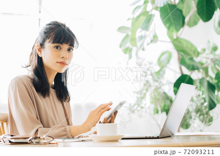 スマホを持つテレワークの女性 72093211