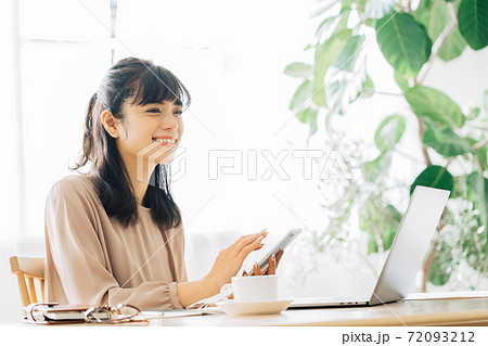 スマホを持つテレワークの女性 72093212