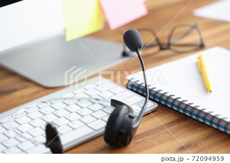 On table are headphones with microphone and keyboard, diary and pen On table are headphones with microphone and keyboard, diary and pen 72094959