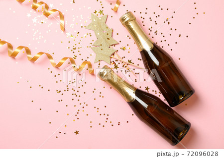 Bottles of champagne and glitter on pink background 72096028