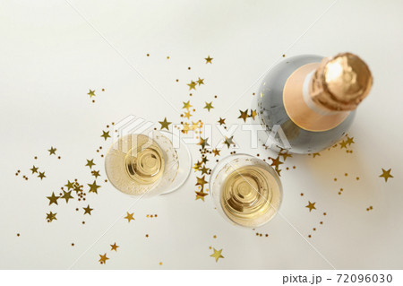 Bottle and glasses of champagne and glitter on white background 72096030