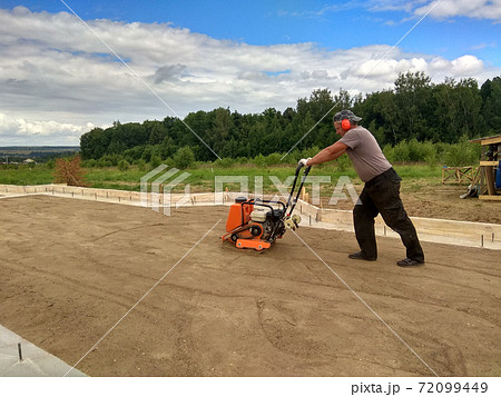 Soil compaction by a worker with a vibroplate 72099449