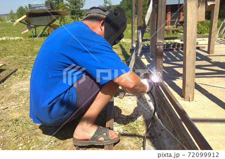 a man weld metal on the street 72099912