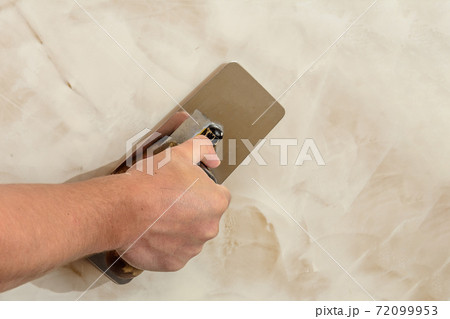polishing the Venetian plaster on the wall master polishing the Venetian plaster on the wall master 72099953