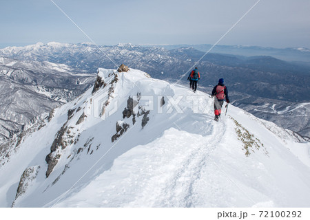 長野の白馬にある冬季唐松岳の八方尾根ルート上の登山者と青空の写真素材