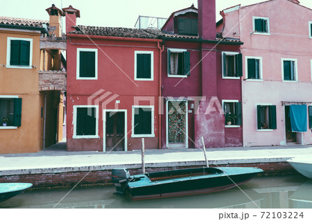 Panoramic view of coloured homes and water canal with boats in Burano Panoramic view of coloured homes and water canal with boats in Burano 72103224
