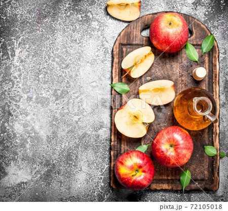 Apple cider vinegar with fresh apples on cutting Board. 72105018