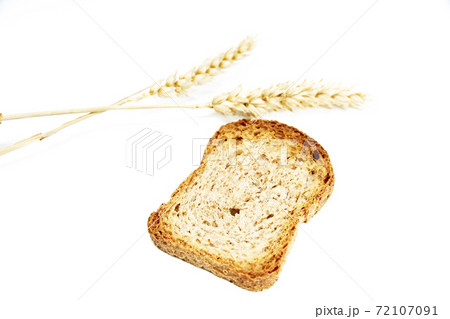 Crusty bread toast slice next to two ears of wheat on white background Crusty bread toast slice next to two ears of wheat on white background 72107091