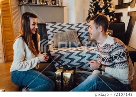 a guy and a girl celebrate the new year together. and give each other gifts a guy and a girl celebrate the new year together. and give each other gifts 72107143