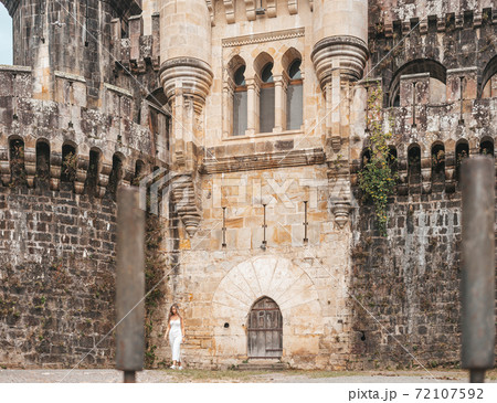 Young woman in front of a medieval castle Young woman in front of a medieval castle 72107592
