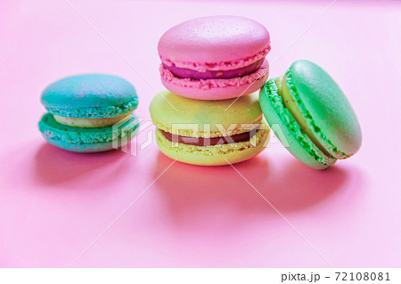 Sweet almond colorful pink blue yellow green macaron or macaroon dessert cake isolated on trendy pink pastel background. French sweet cookie. Minimal food bakery concept. Flat lay top view, copy space Sweet almond colorful pink blue yellow green macaron or macaroon dessert cake isolated on trendy pink pastel background. French sweet cookie. Minimal food bakery concept. Flat lay top view, copy space 72108081