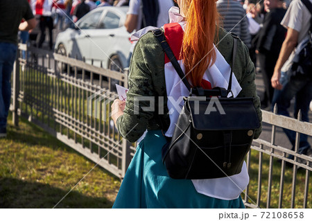 A young woman wrapped in a flag with a briefcase walks during a demonstration A young woman wrapped in a flag with a briefcase walks during a demonstration 72108658