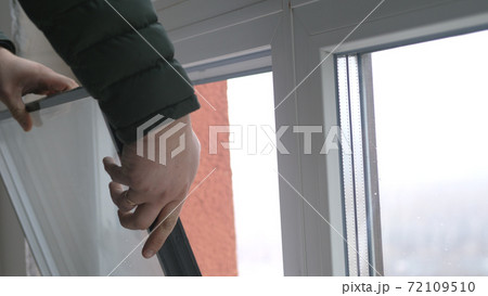 Windows installation worker, construction worker sets of plastic window. Close up of hand 72109510
