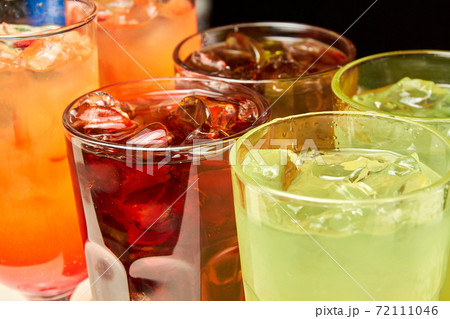 Multicolored alcoholic and non-alcoholic cocktails with ice and straws Multicolored alcoholic and non-alcoholic cocktails with ice and straws 72111046