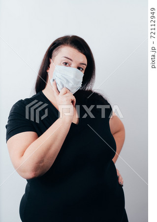 Doubtful pensive woman wearing a face mask Doubtful pensive woman wearing a face mask 72112949