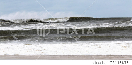 Wide view of rough ocean on windy day with a blue sky 72113833