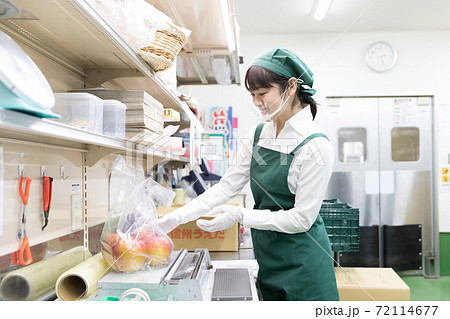 スーパーの裏方で働く人々 袋詰め ラッピングの写真素材