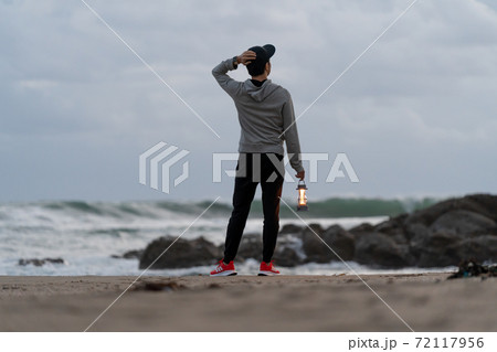 二地域居住で週末、早朝に浜を散歩して有意義に過ごしている男性 72117956